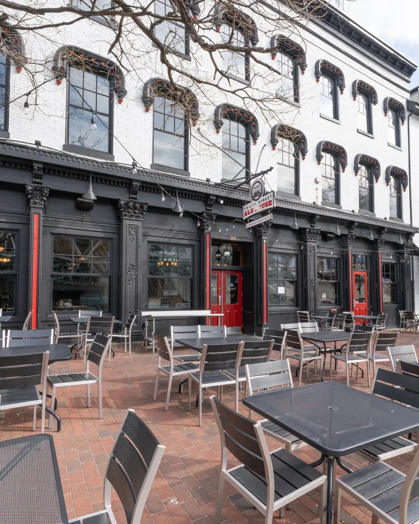 The Pratt Street Ale House frontage on West Pratt Street, red doors and the sidewalk patio
