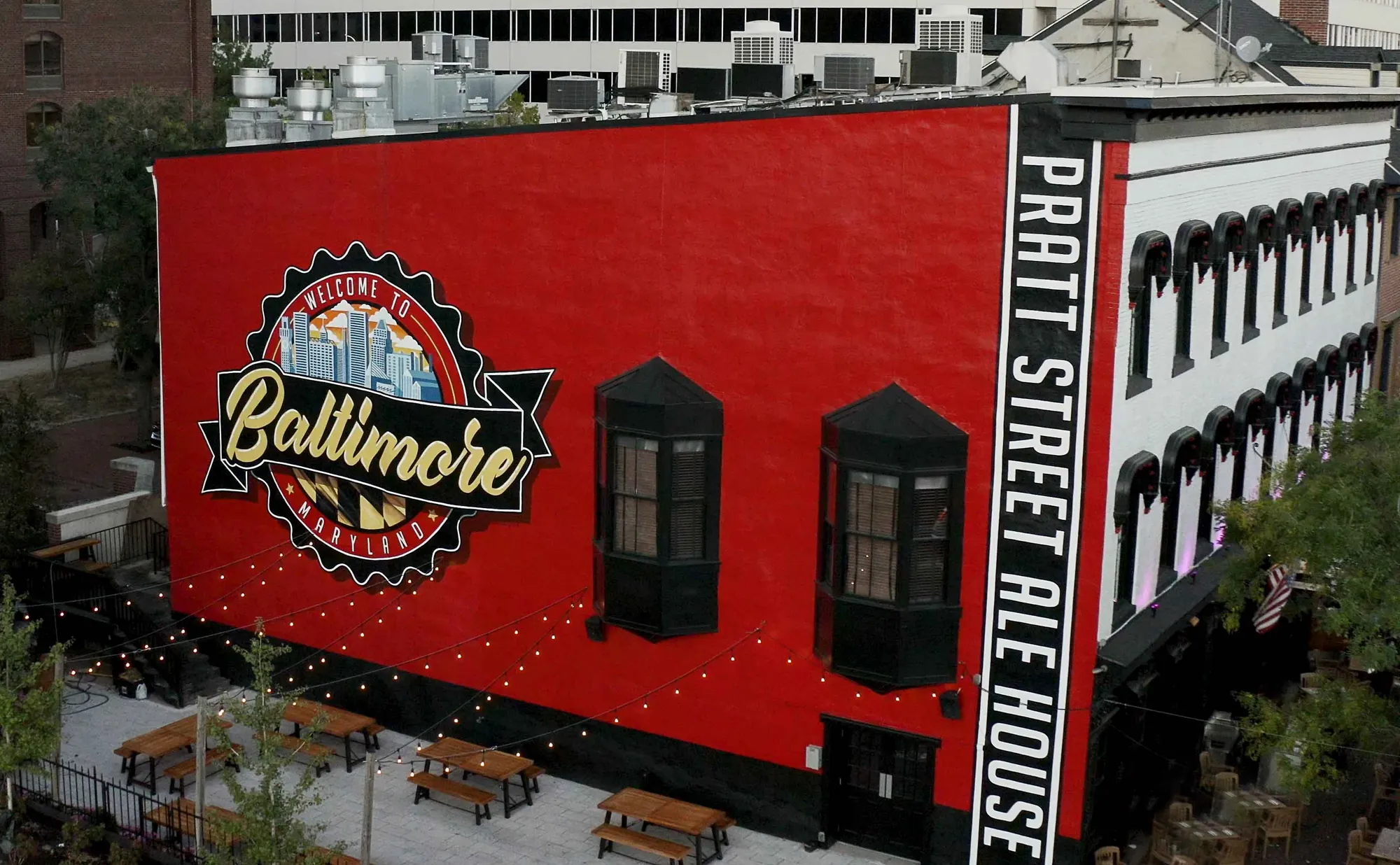 The Welcome to Baltimore mural on the side of the Pratt Street Ale House building, with the beer garden below